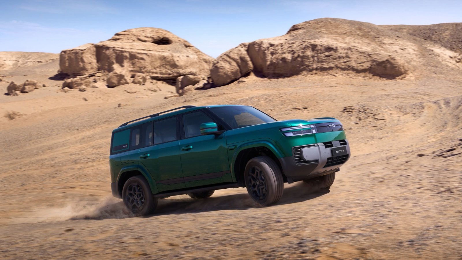 Green BYD Ti7 driving in a desert landscape