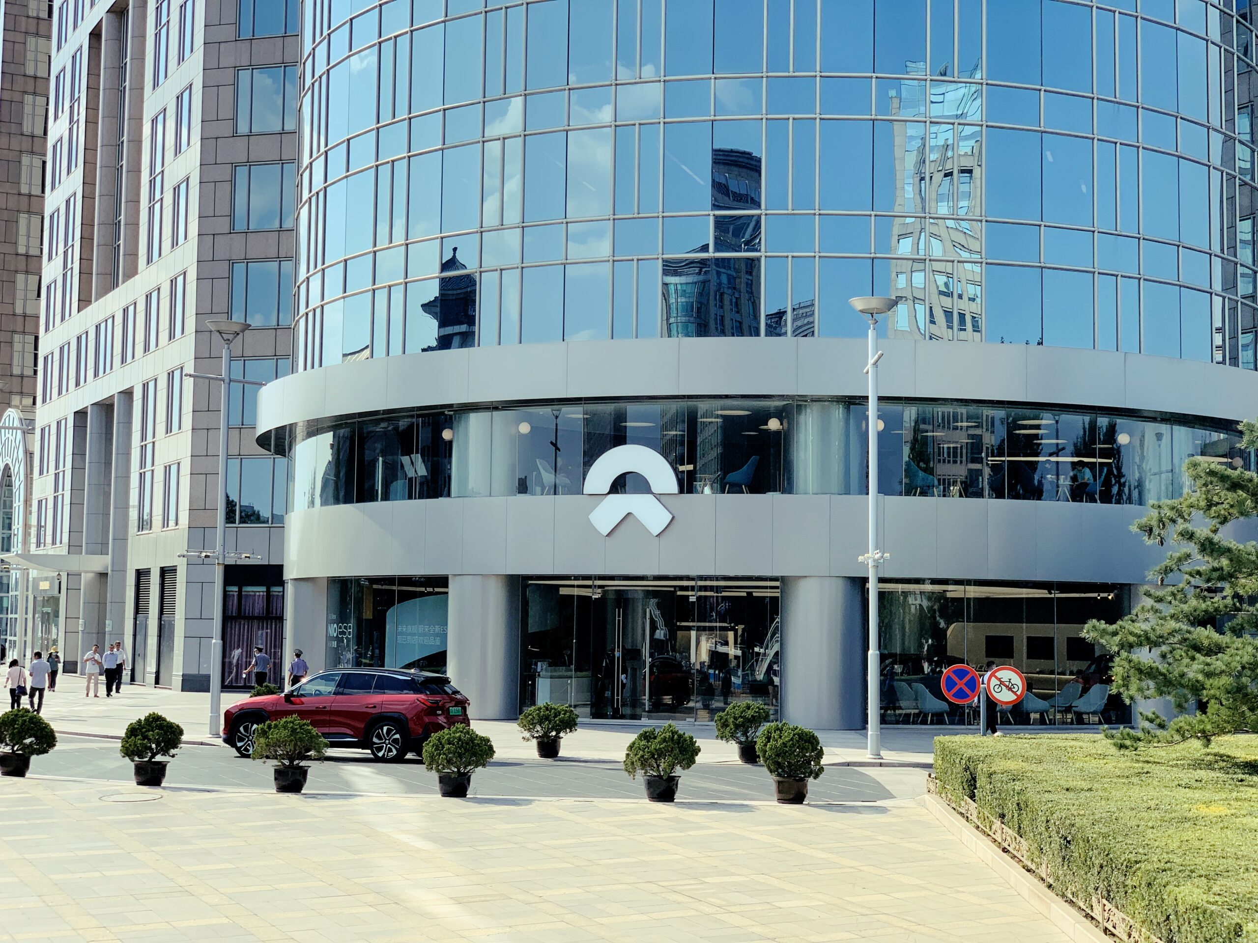 NIO House glass-fronted building in Beijing with a red vehicle outside
